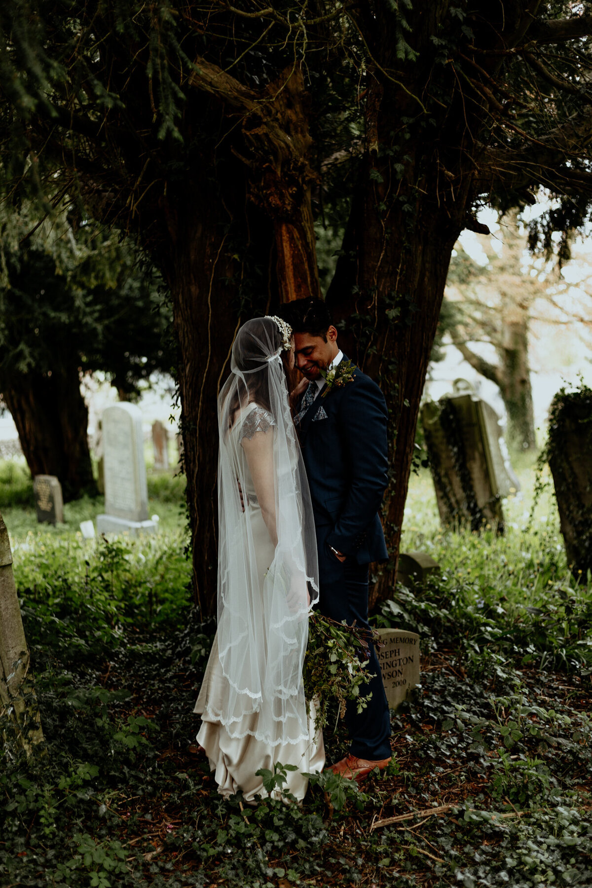 bride and groom facing eachother in the woods