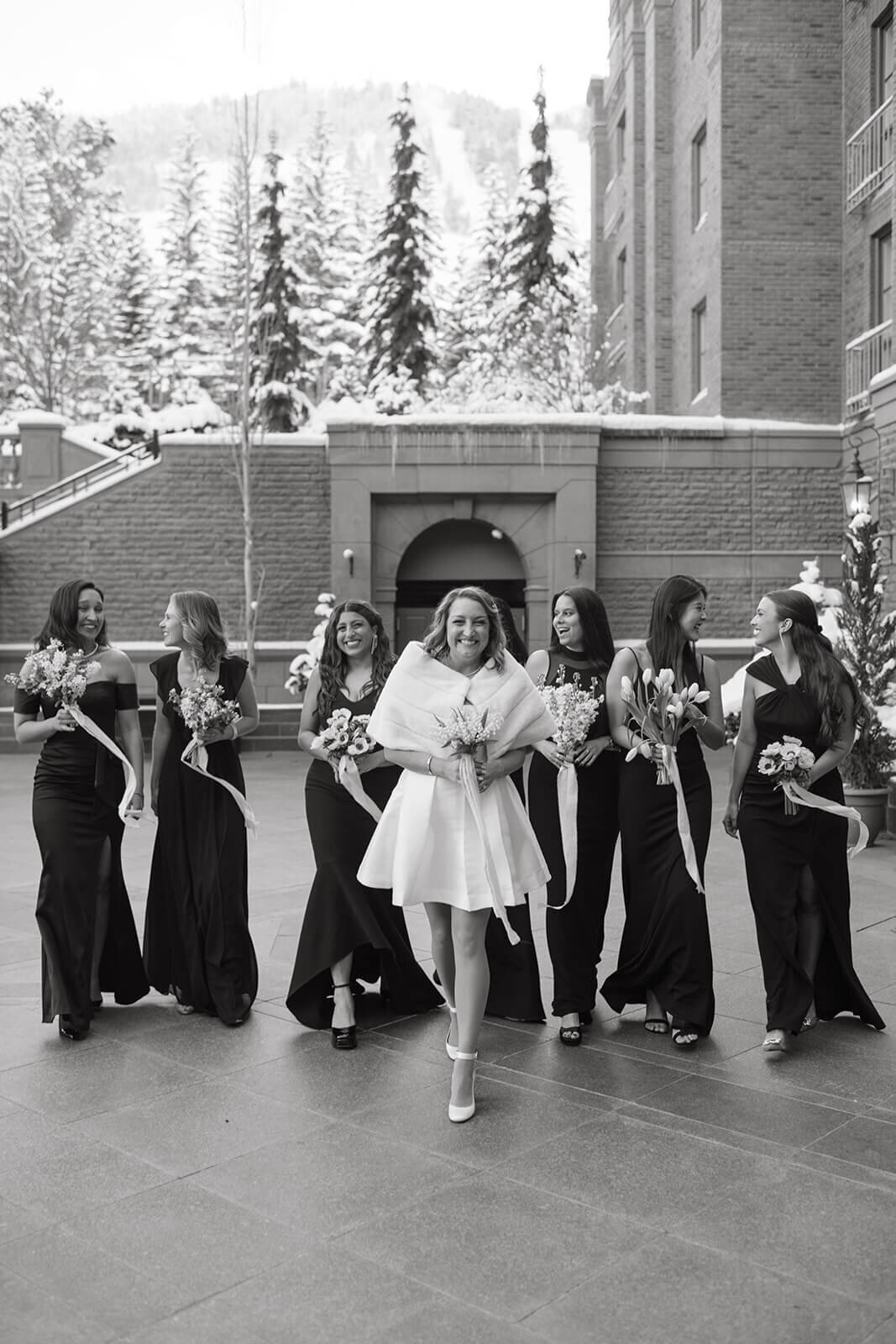 Bride and bridesmaids laughing together at St. Regis Aspen, captured in a timeless black-and-white moment with elegant details.