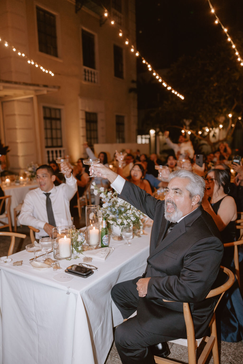 Guests raising a glass,father of the bride yelling and smiling