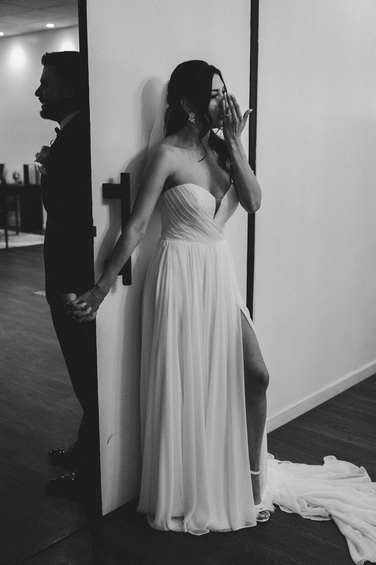 Bride wiping away tear during her first look with groom at the croft downtown