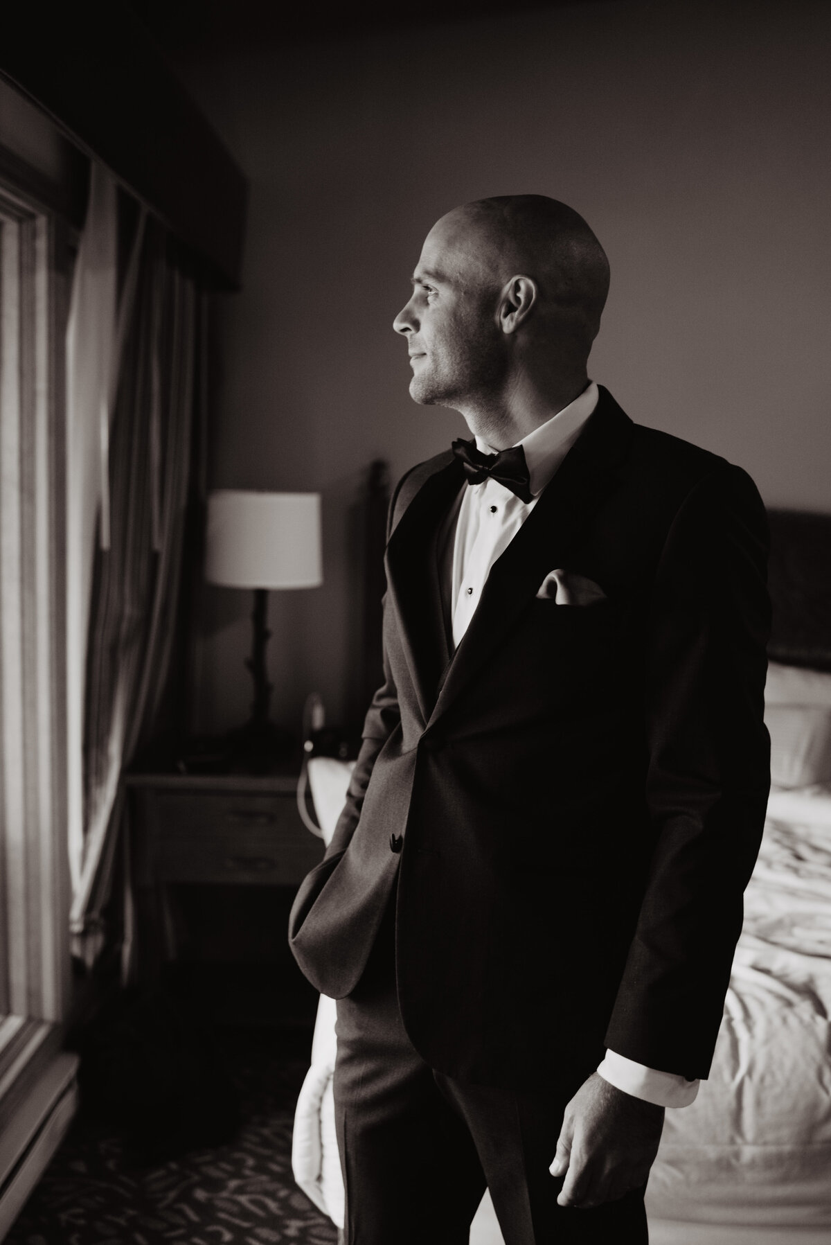 Jackson Hole photographers capture groom wearing tuxedo looking outside