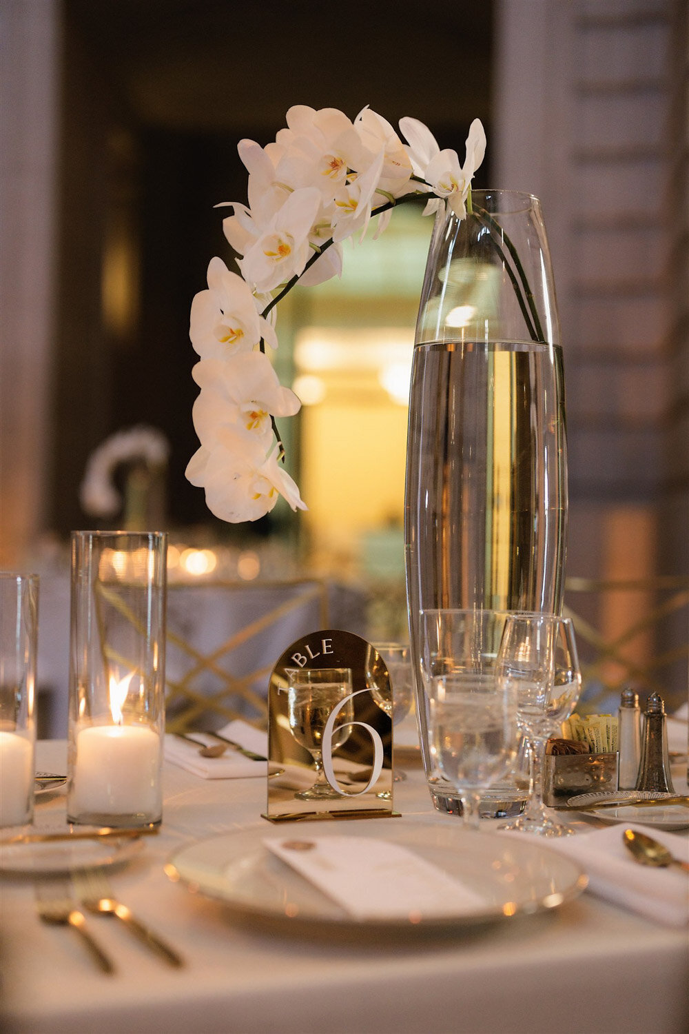 Wedding reception table with glasses and minimalist floral centerpiece