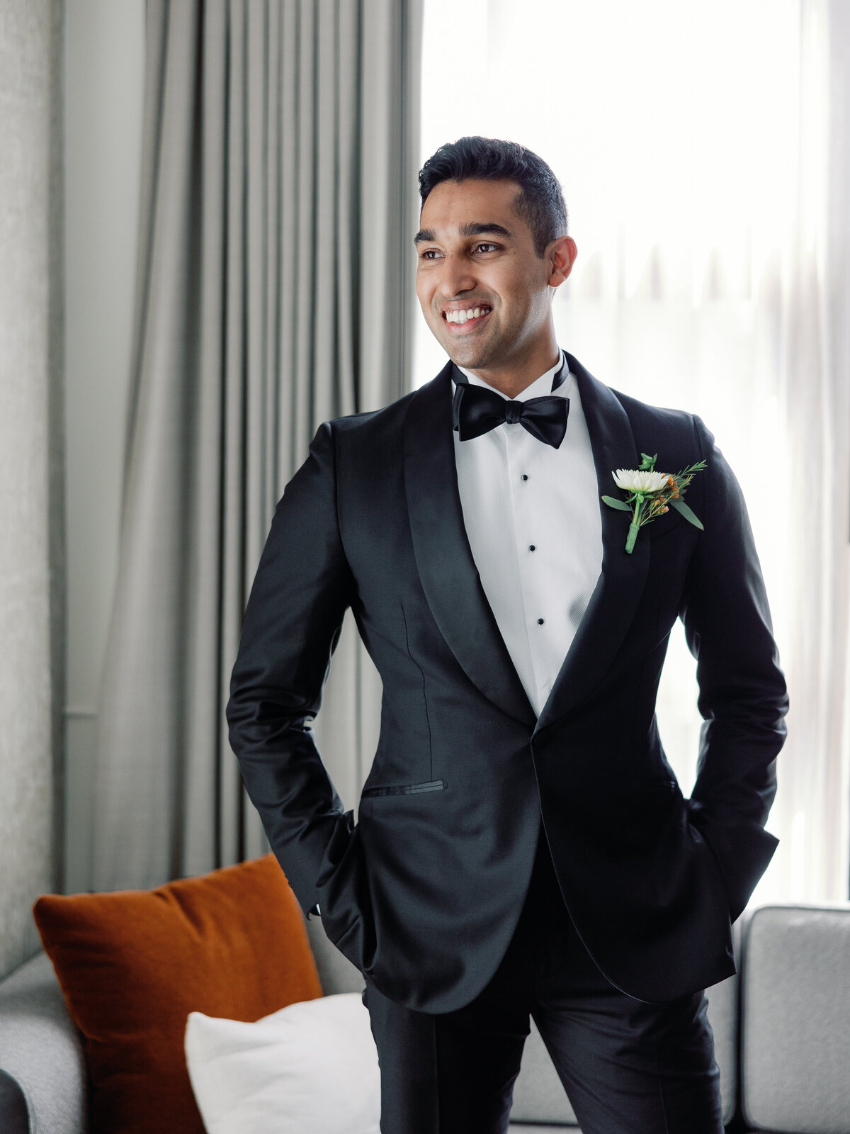 A groom portrait as he stands with his hands in his pockets