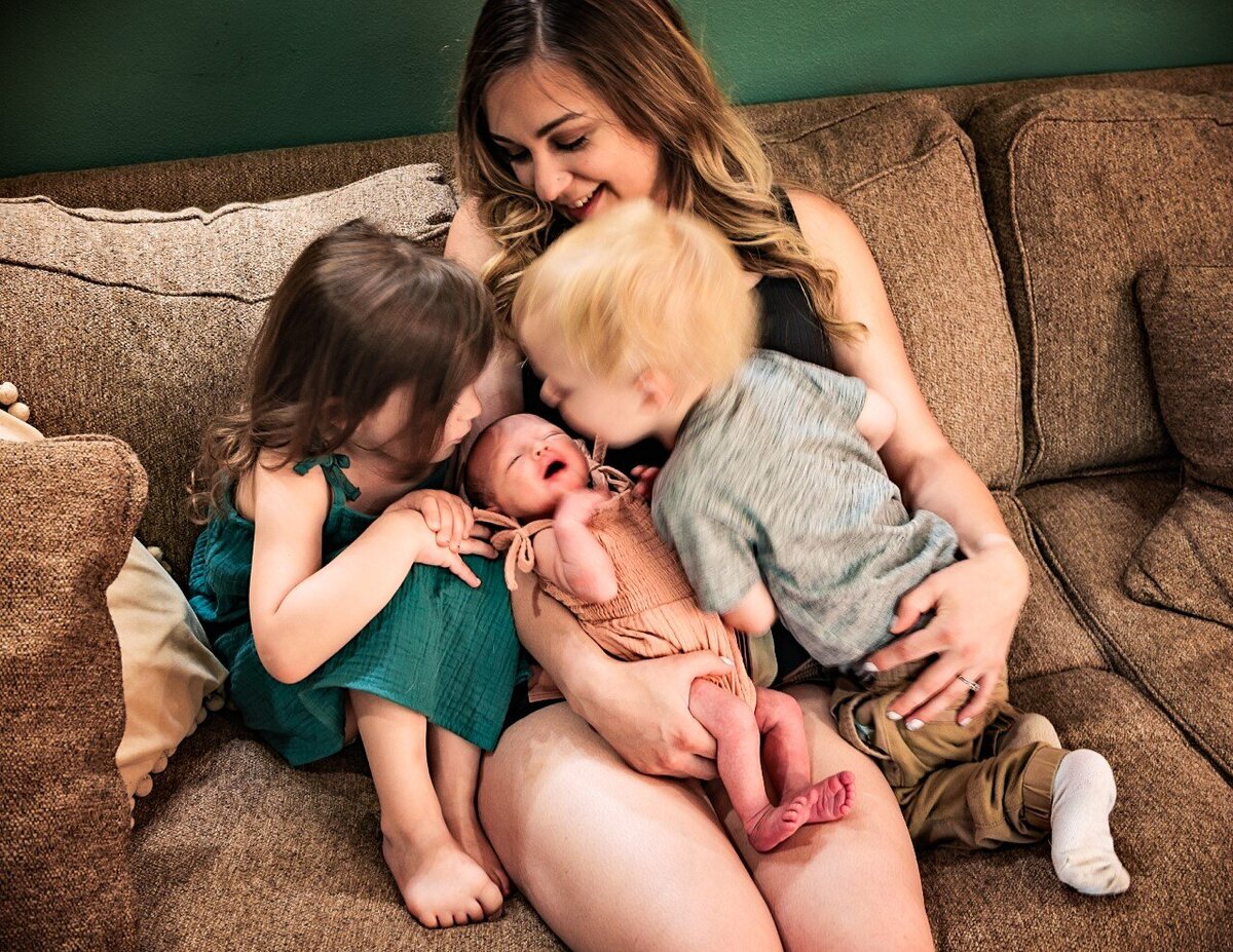 kids kissing newborn sister