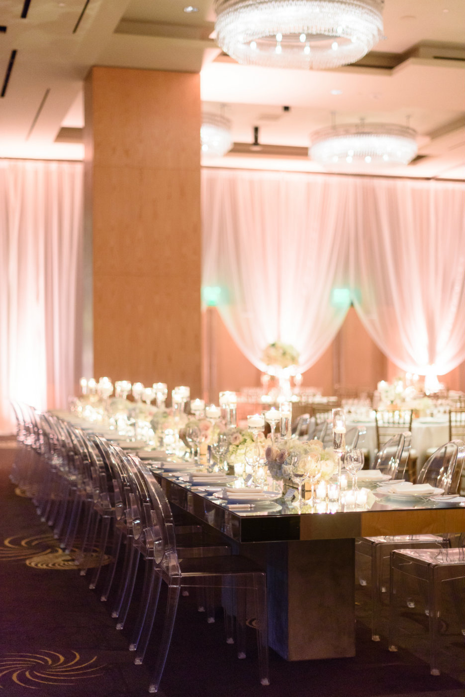 Mirrored tables lined with candles and white flowers and clear lucite chairs are perfect for a winter wedding.