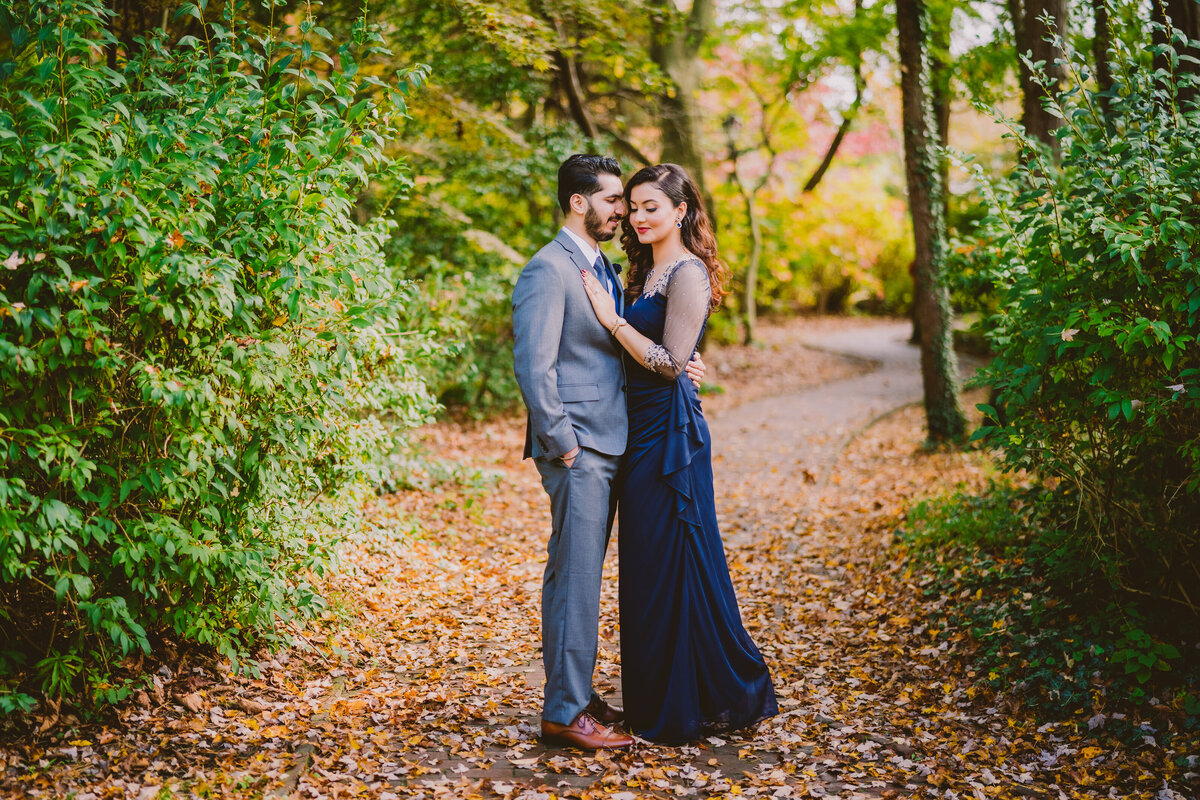 An engaged couple wearing formal outfits share moment at the sayen gardens in nj with fall leaves