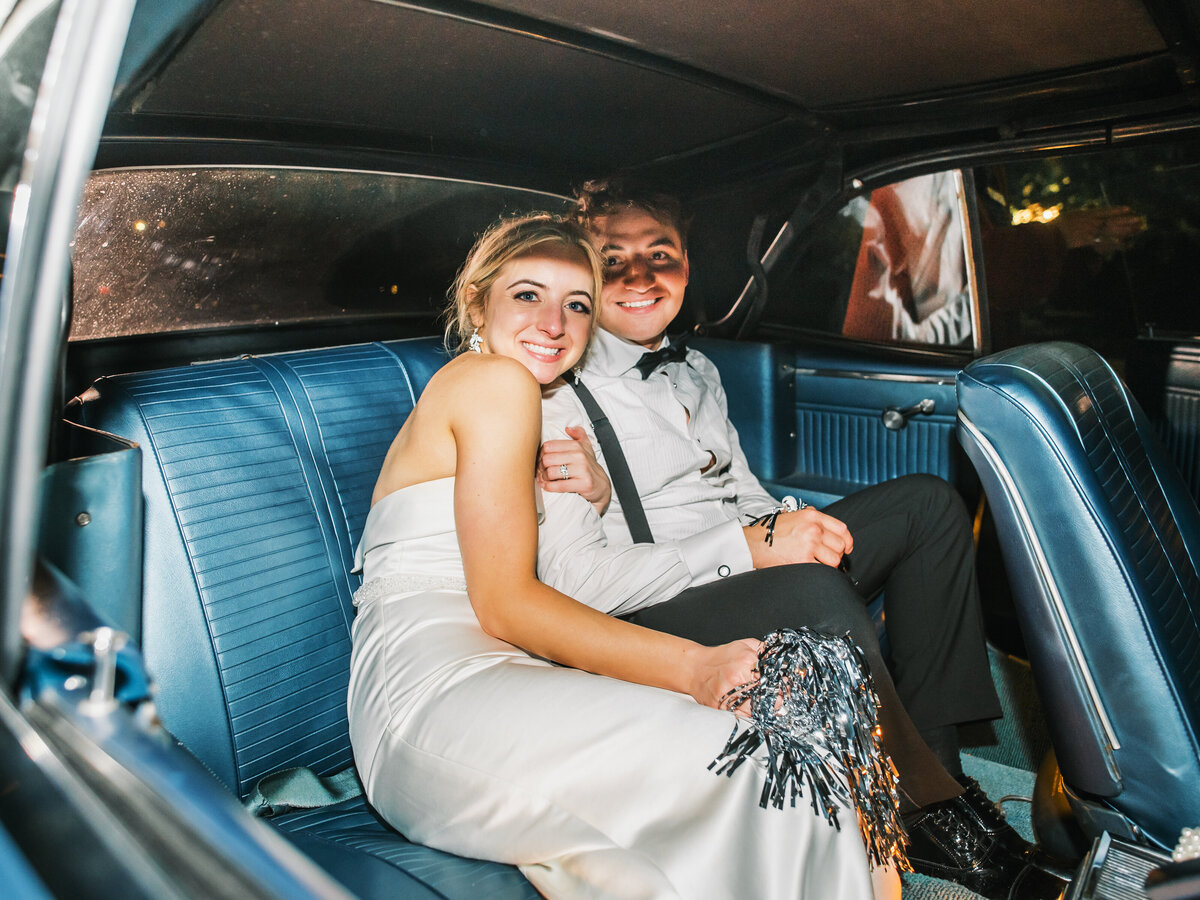 Bride and groom seated in a vintage getaway car after their wedding exit at Old Edwards Inn in Highlands, North Carolina.