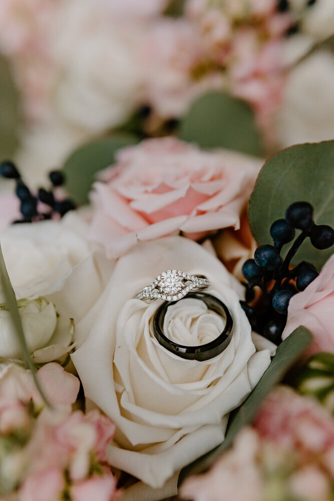 storyteller-collective-photo-co-wedding-rings-on-flower-bouquet-iowa