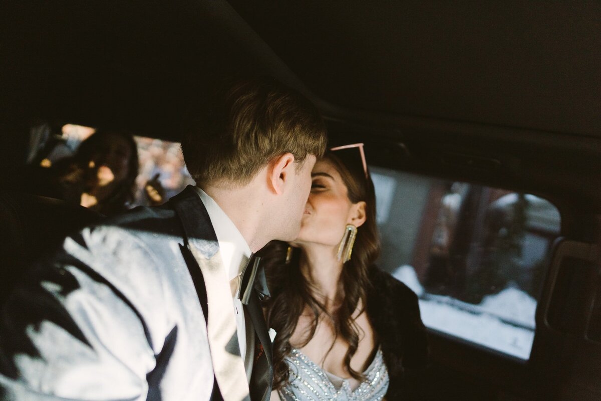 bride and groom kissing in the car