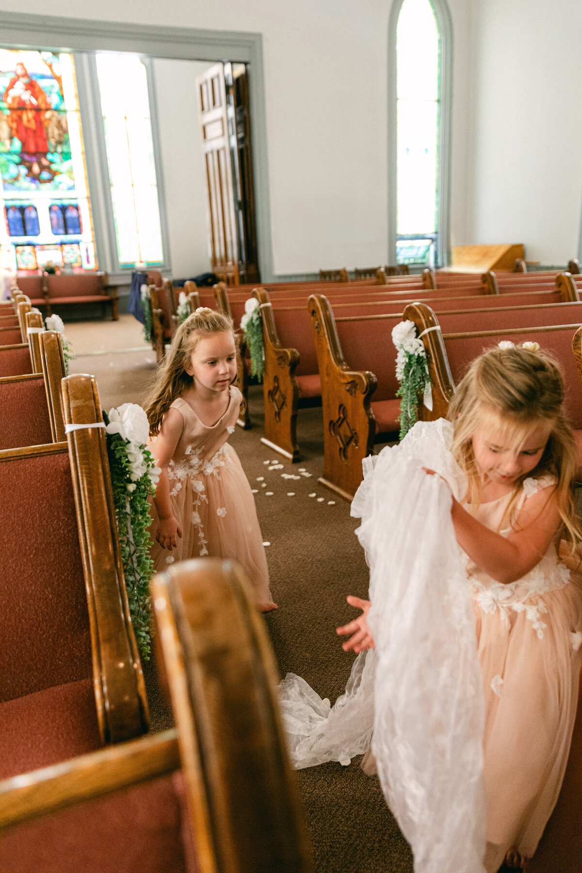 flower-girls-playing-with-veil-church-aisle