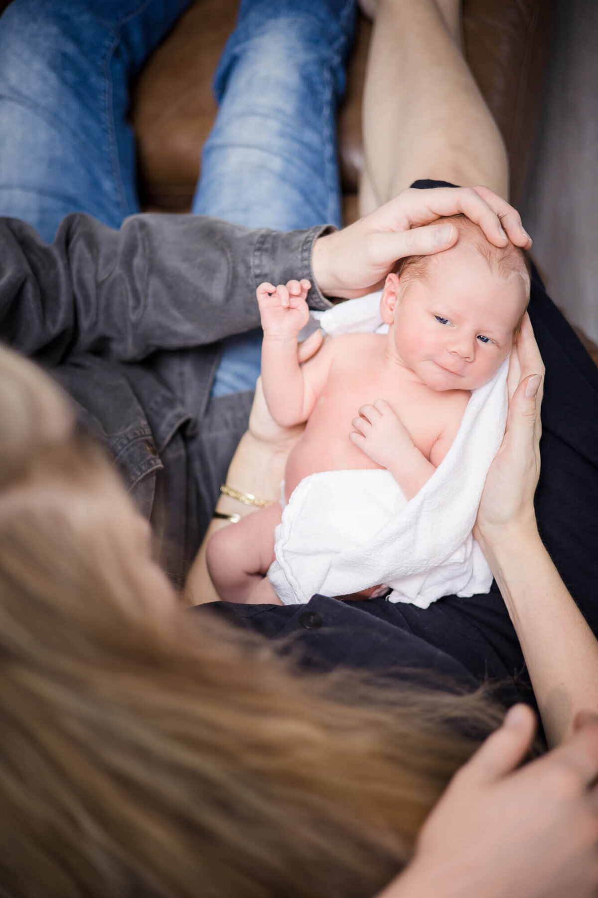 happy and awake newborn baby boy looking at his parents