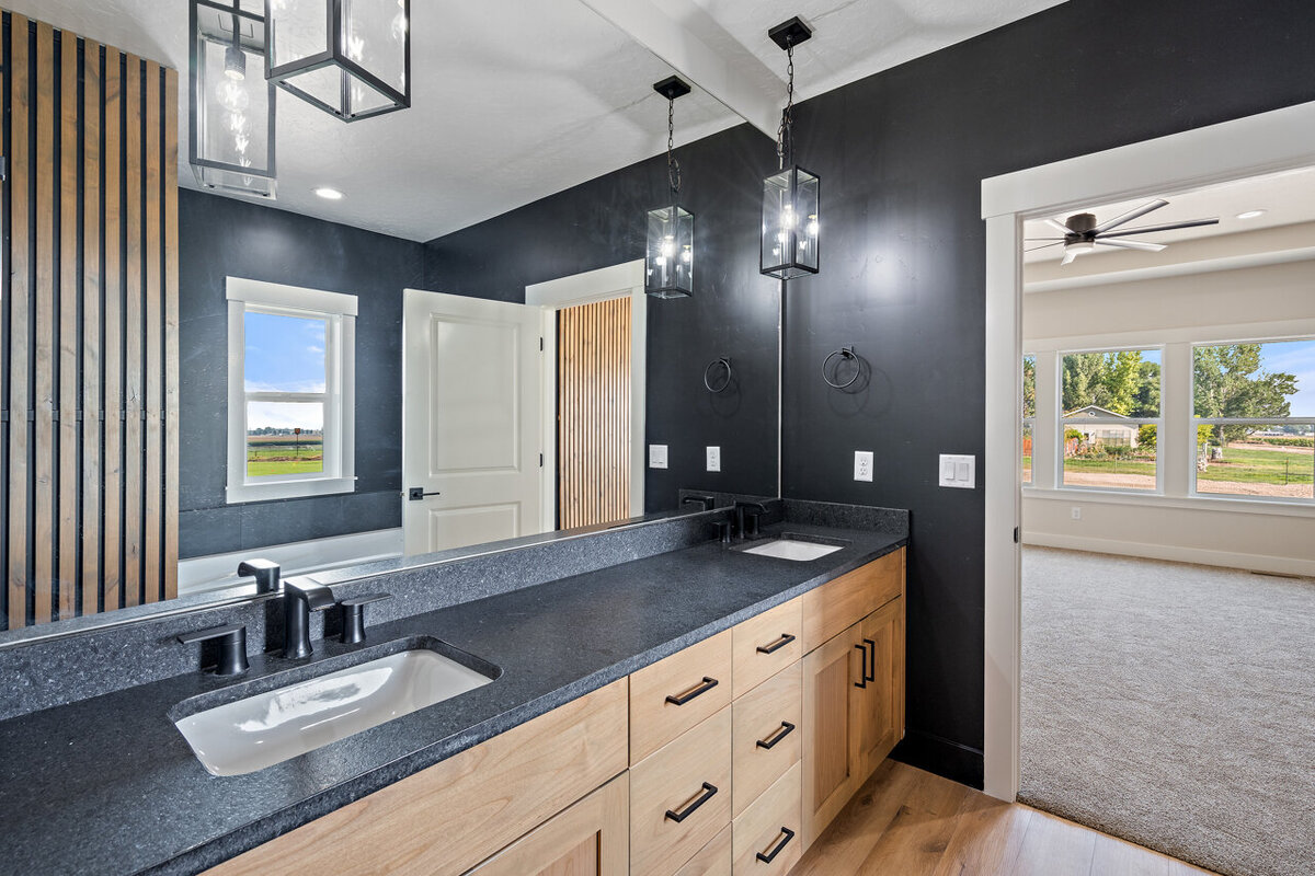 modern kitchen with black walls and counter tops wooden cabinets and floors