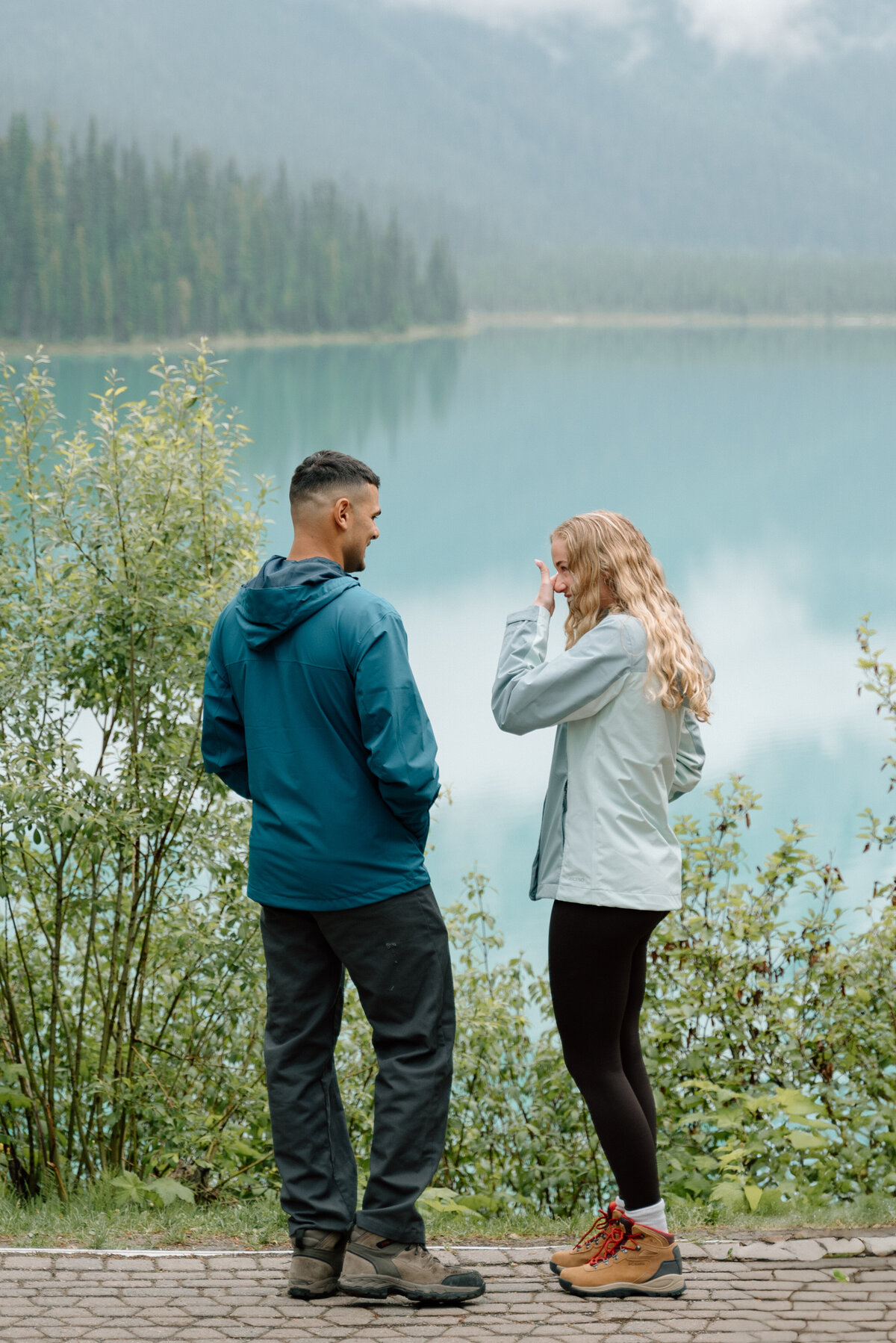 Woman crying tears of joy after being proposed to by boyfriend at Emerald lake. 