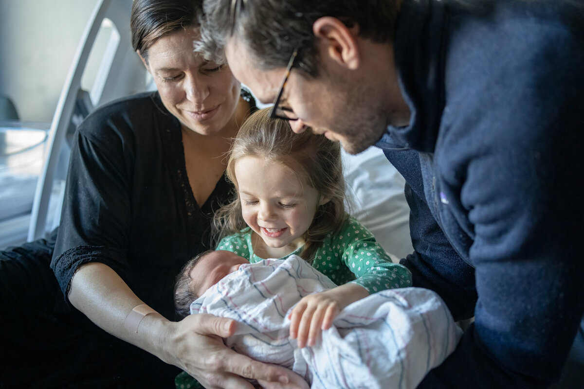 Family cuddling around newborn baby boy