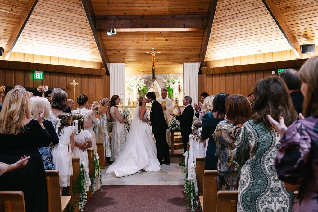 Bride and groom share their first kiss during a traditional church ceremony before their Bascom Center wedding in Highlands NC.