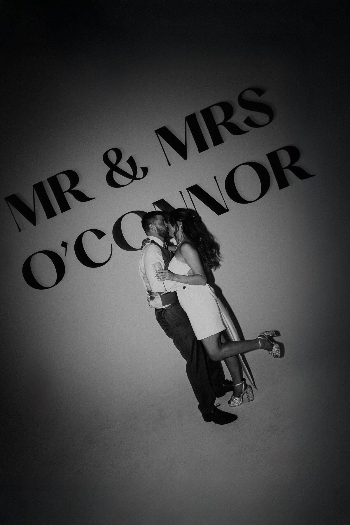 A Bride and Groom kiss in front of their decal at Shoreditch Studios on their wedding day. 