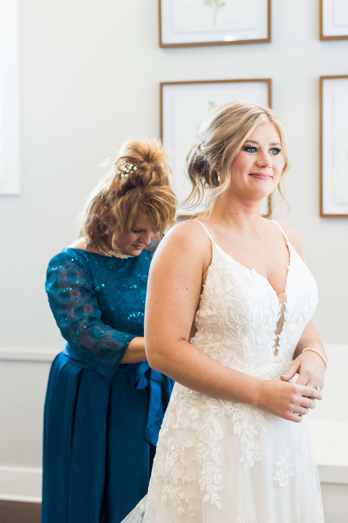 Bride having dress fixed by mother at  The Barn at White Oaks, Murray, Kentucky