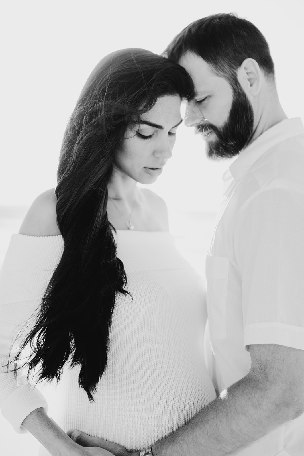 A couple shares a quiet, intimate moment during their Miami maternity session.
