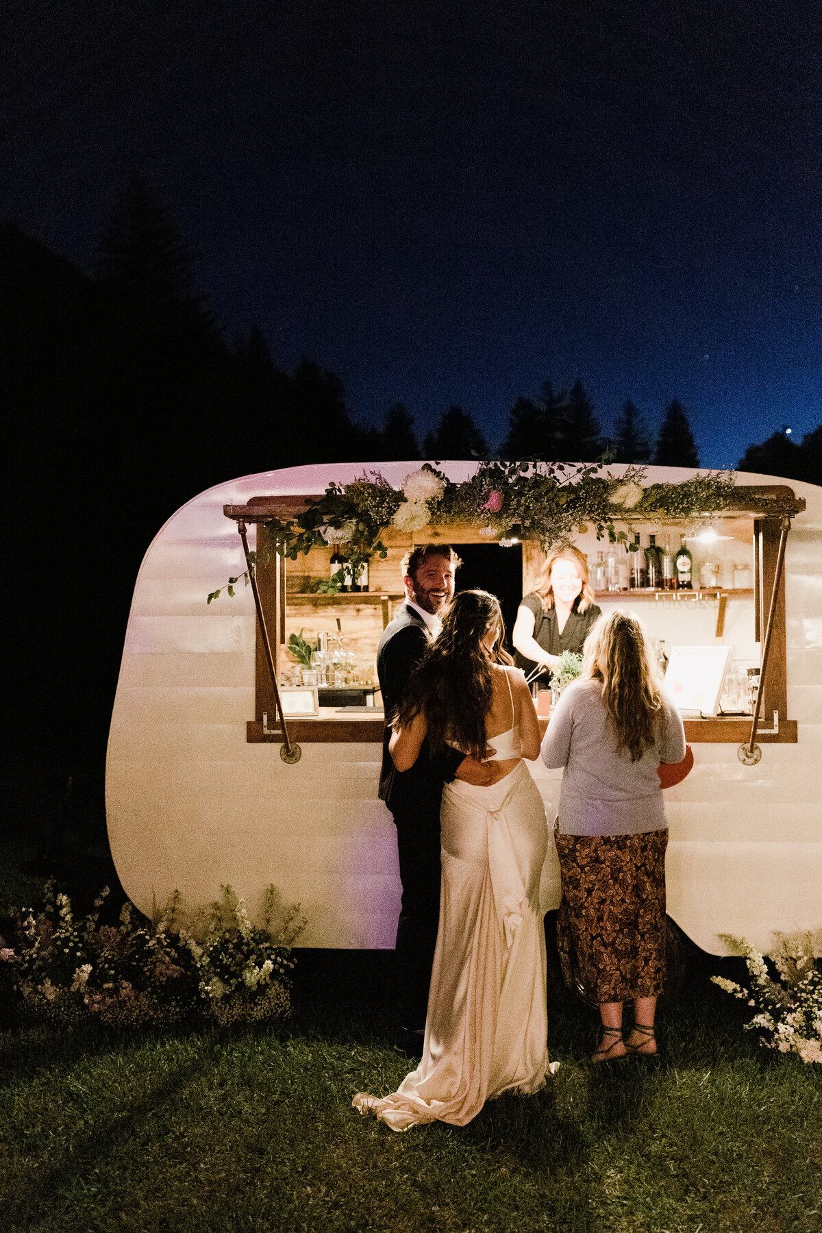 Bride and groom ordering drinks from mobile cocktail bar at Dallenbach Ranch Wedding in Colorado