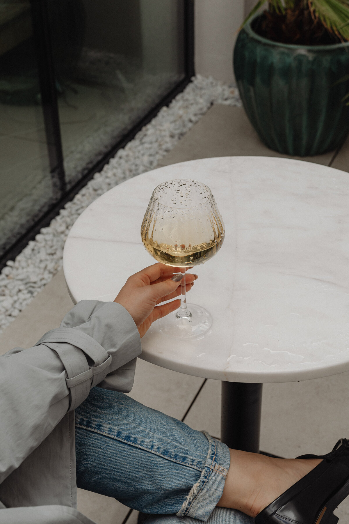 White marble table, wine glass, sunglasses
