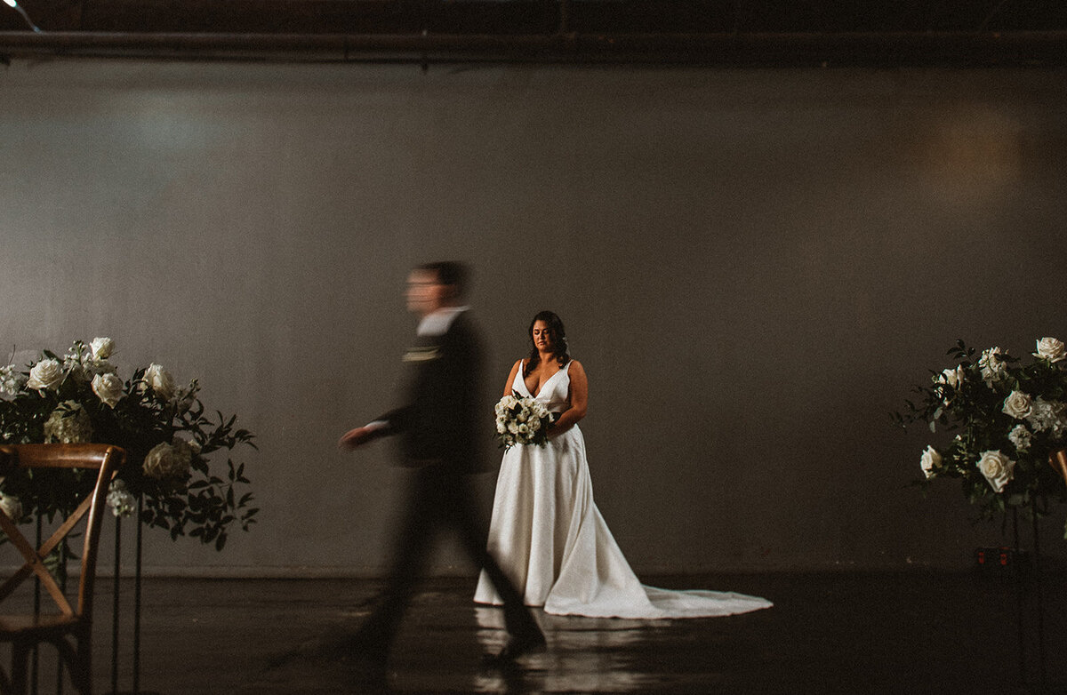 groom briskly walks past bride creating motion blur