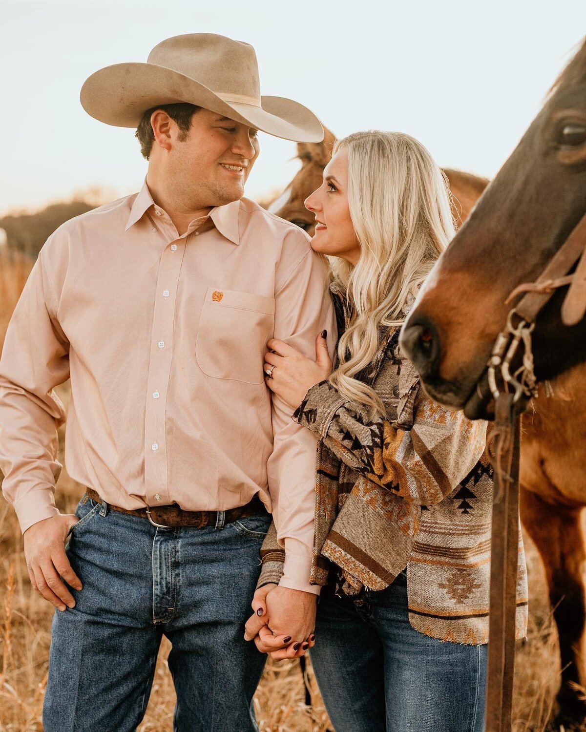 couple posing by horses