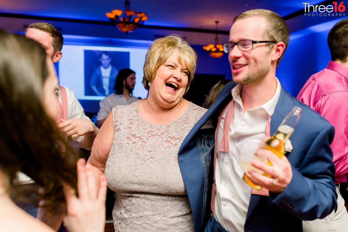 Guests laugh it up on the dance floor at wedding reception