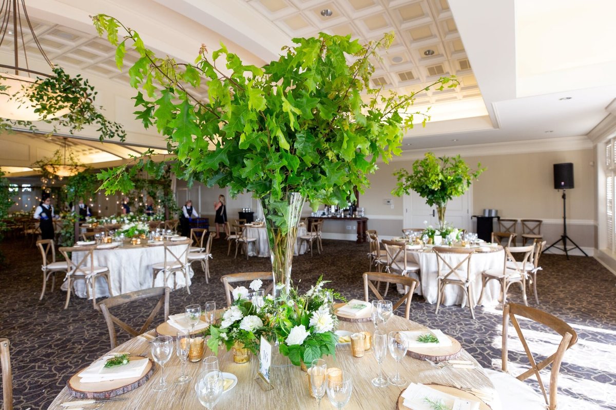 tall greenery centerpiece in glass vase at wedding in Newcastle ballroom