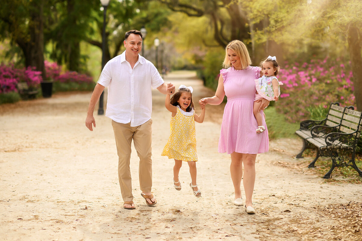 Family plays together among azalea blooms in Hampton Park during their Family Photos in Charleston, SC.
