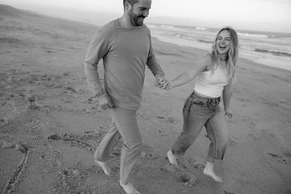 Couple running on beach with engagement photographer in orlando, Marissa Nicole