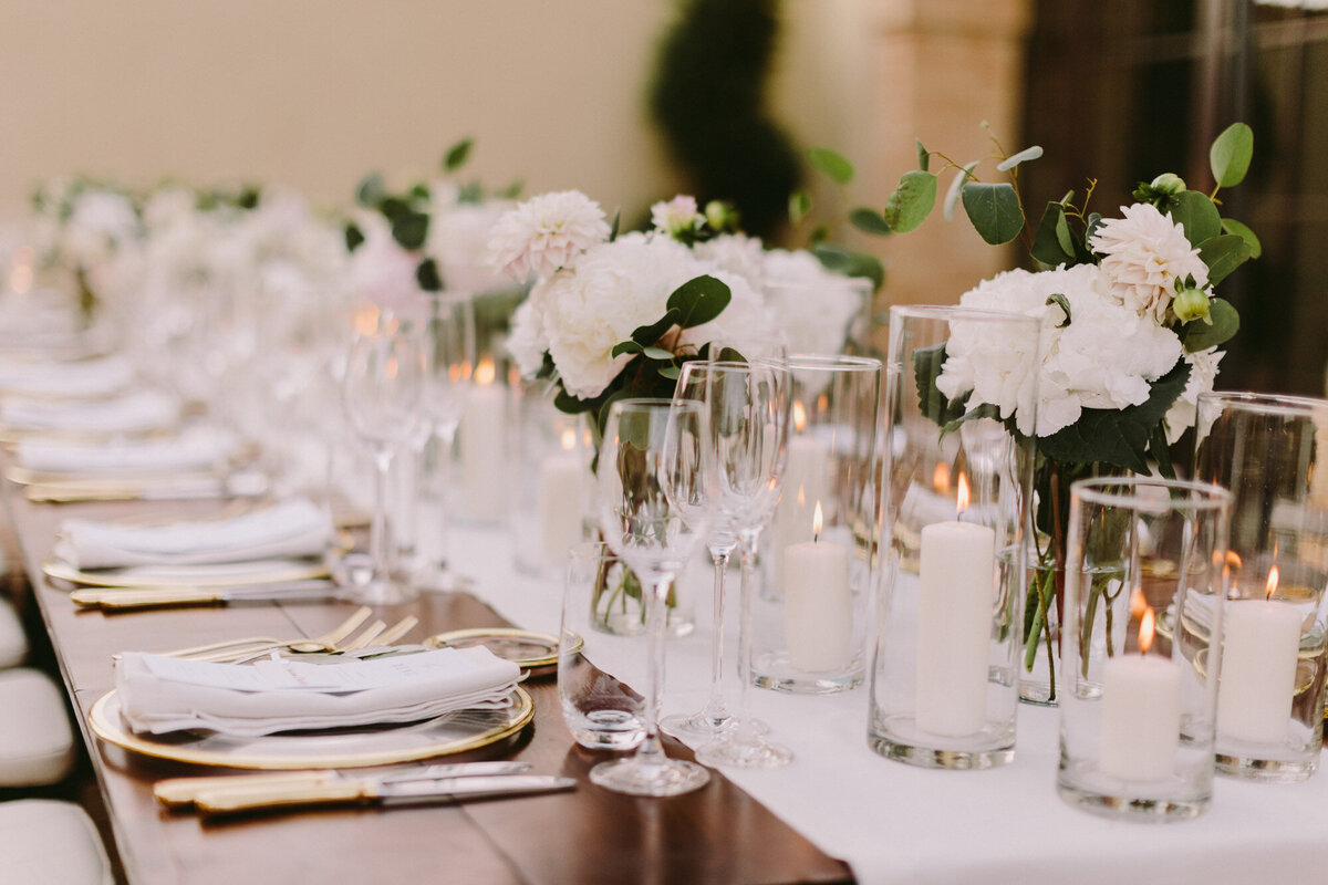 Elegant wedding reception table with white florals and candle lighted centerpieces