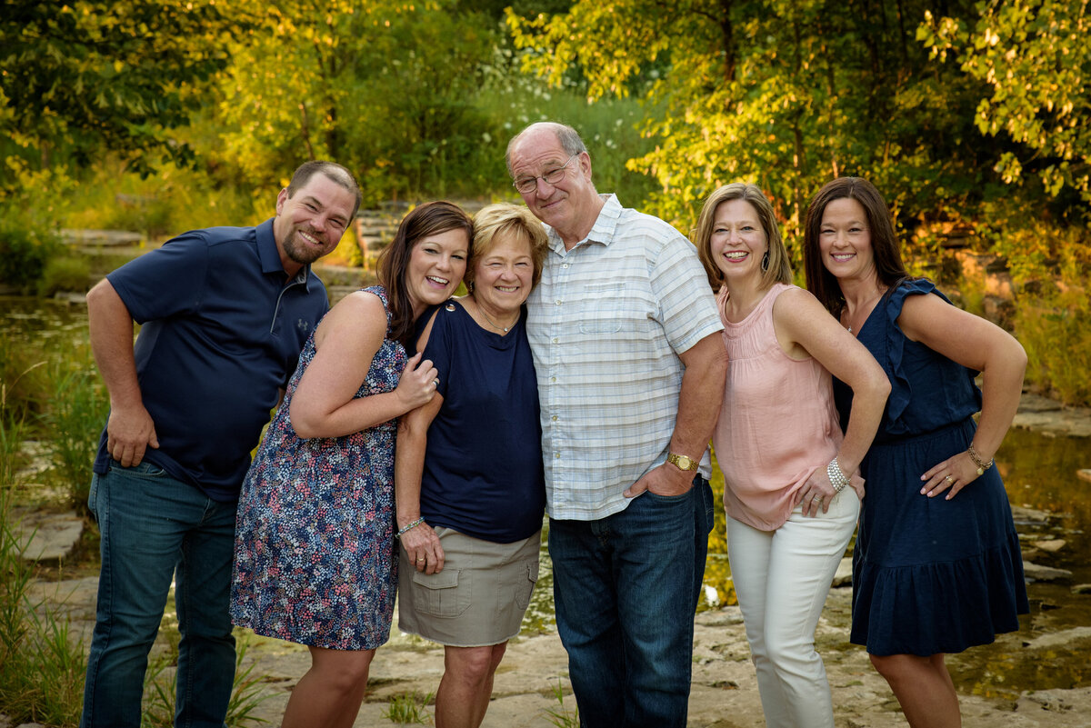 Family portrait with parents and four adult children standing near the creek at Fonferek Glen County Park near Green Bay, Wisconsin