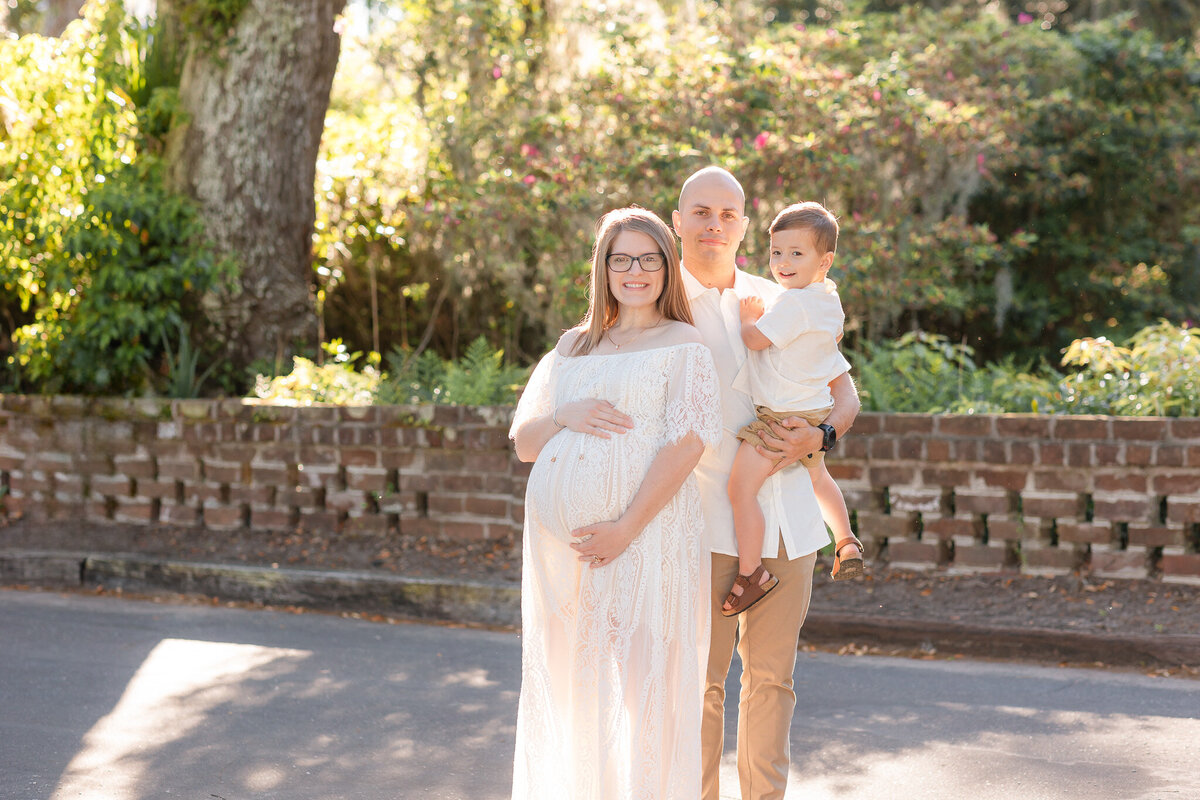 Young mom and dad holding big brother for a maternity session in Savannah, Ga