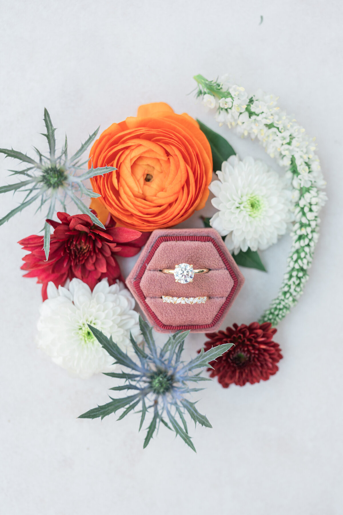 A ring box with flowers laid out around it