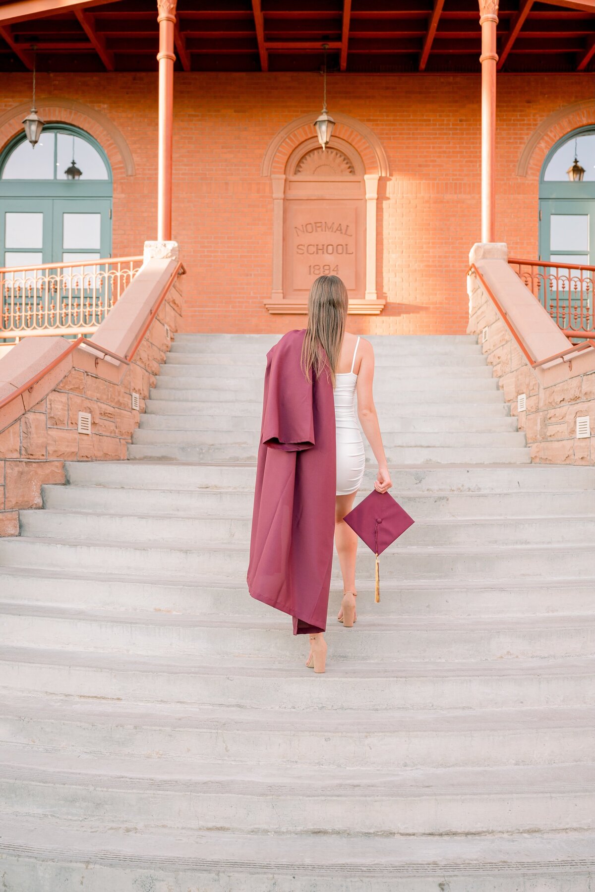 senior girl walking up the stairs at old maine on ASU campus