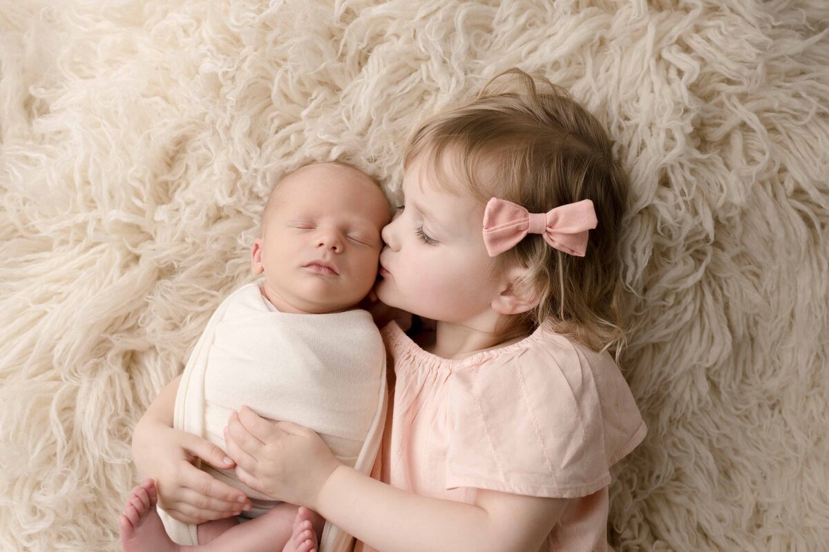Big Sister Kissing Newborn Baby
