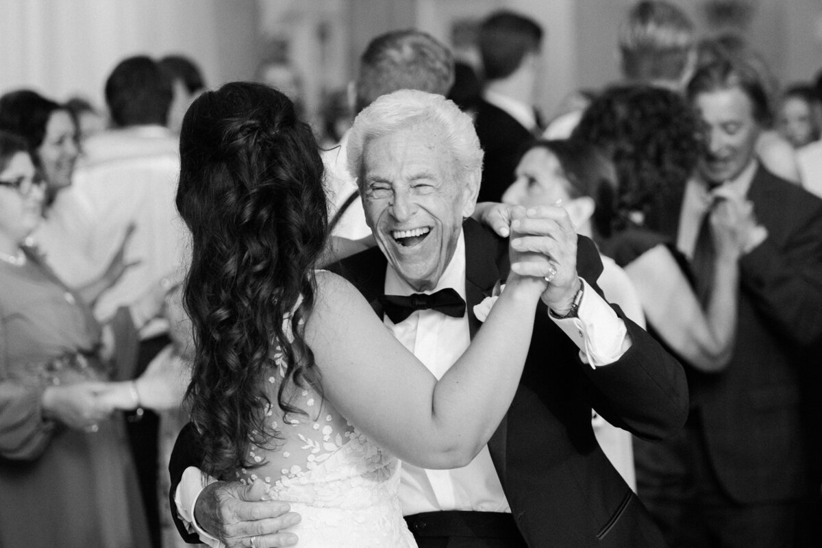 A bride dances with her family member