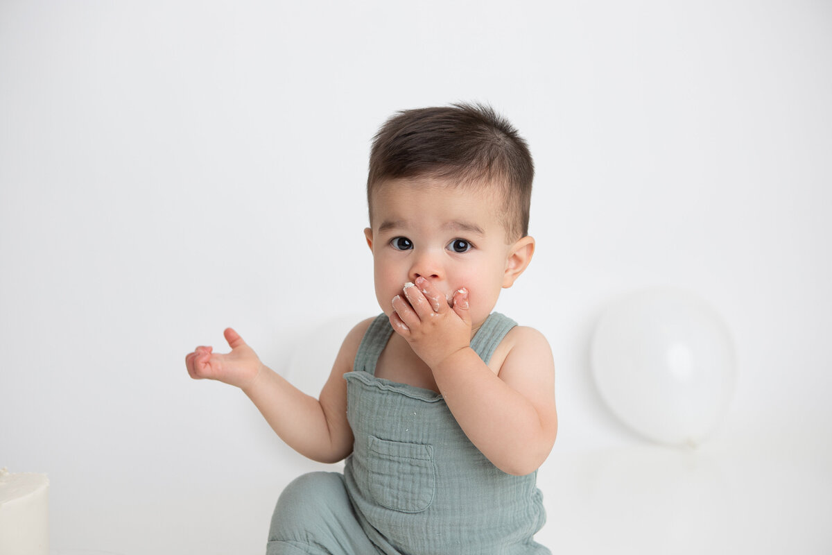 Simple minimalist cake smash with white balloons on the floor
