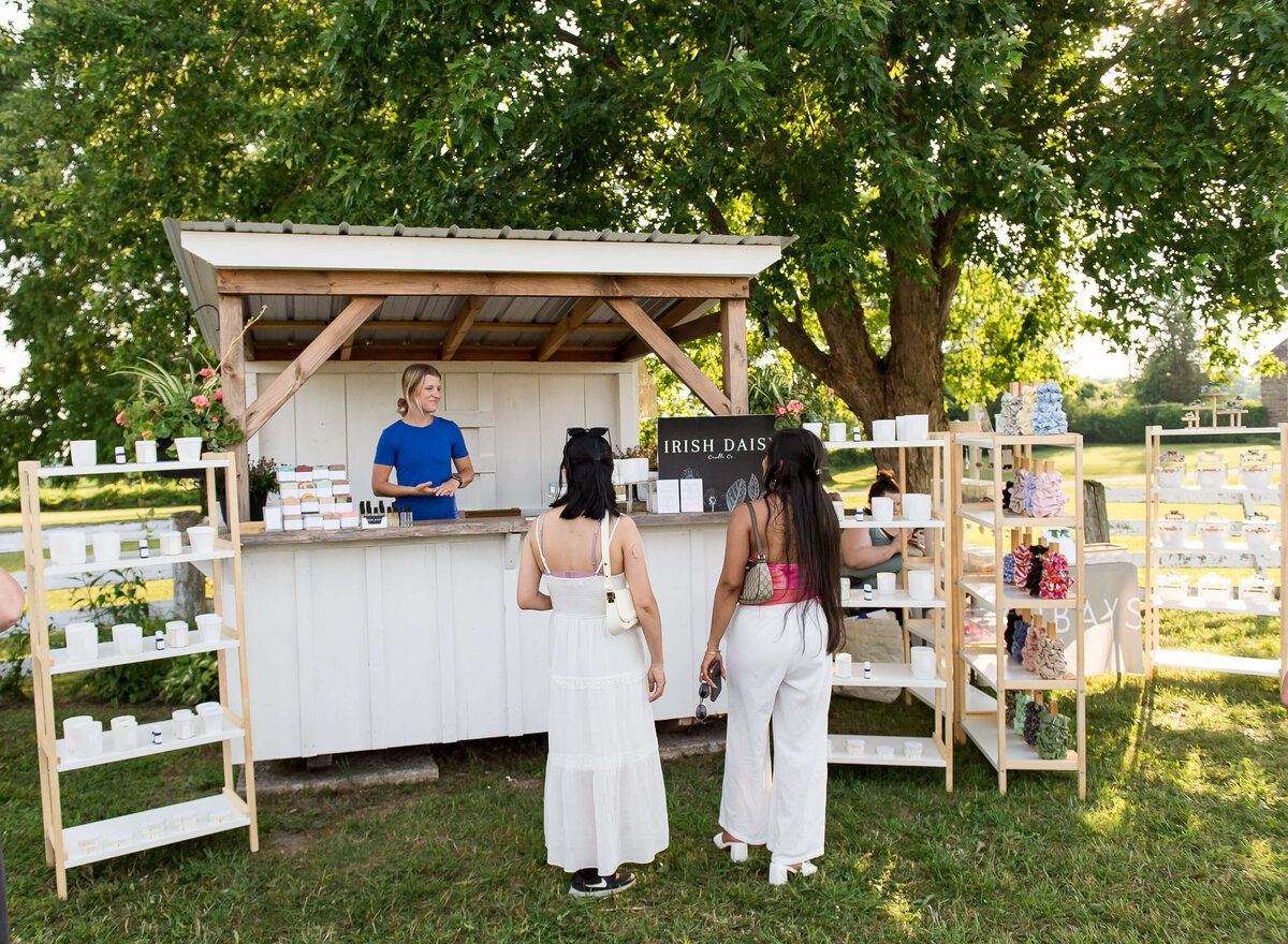 Ottawa event photography showing guests interacting with the market vendors as part of the Soiree in the Field event.  Captured by JEMMAN Photography COMMERCIAL