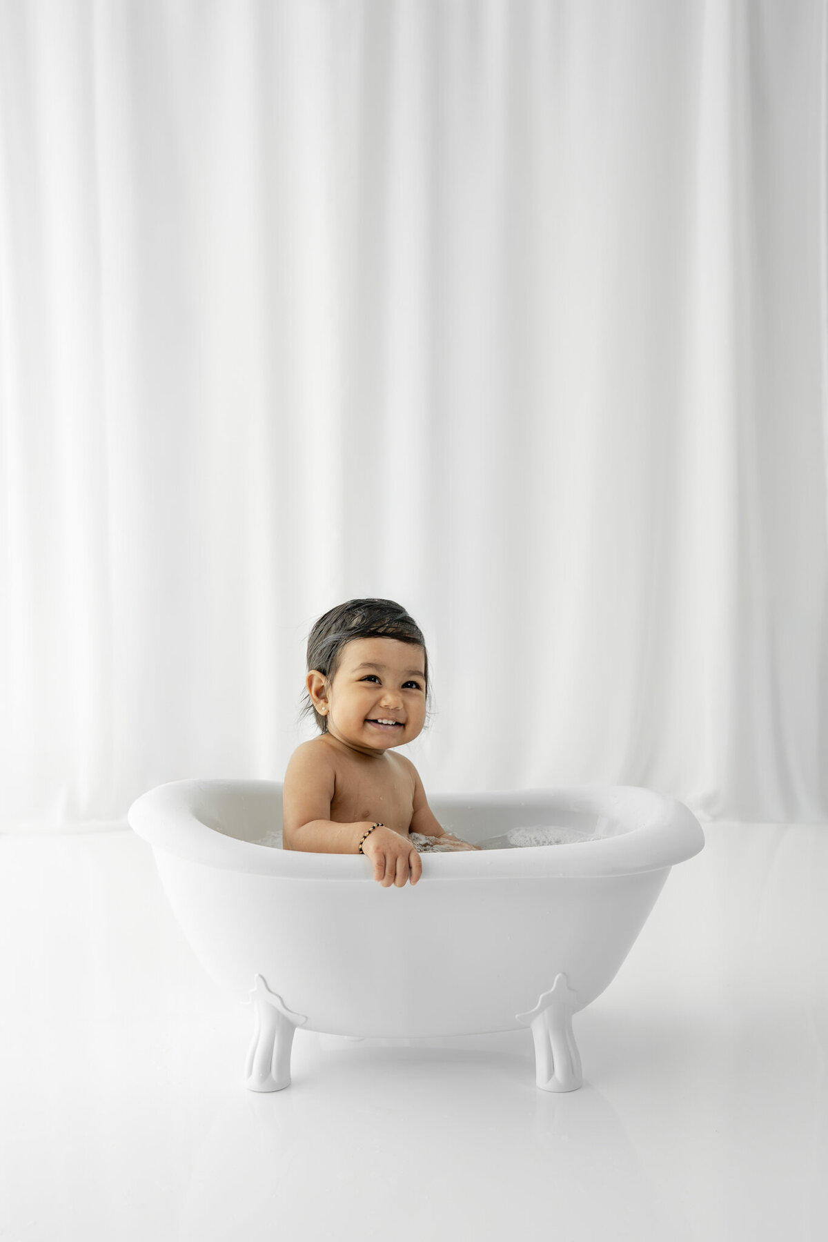 Girl in bubblebath following cake smash session— captured by Alliston and Barrie cake smash photographer.