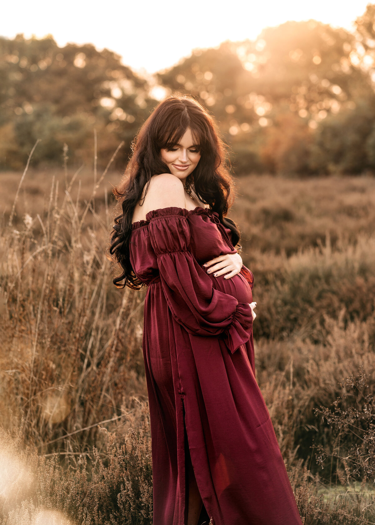 Photo of a pregnant woman in a red dess at sunset