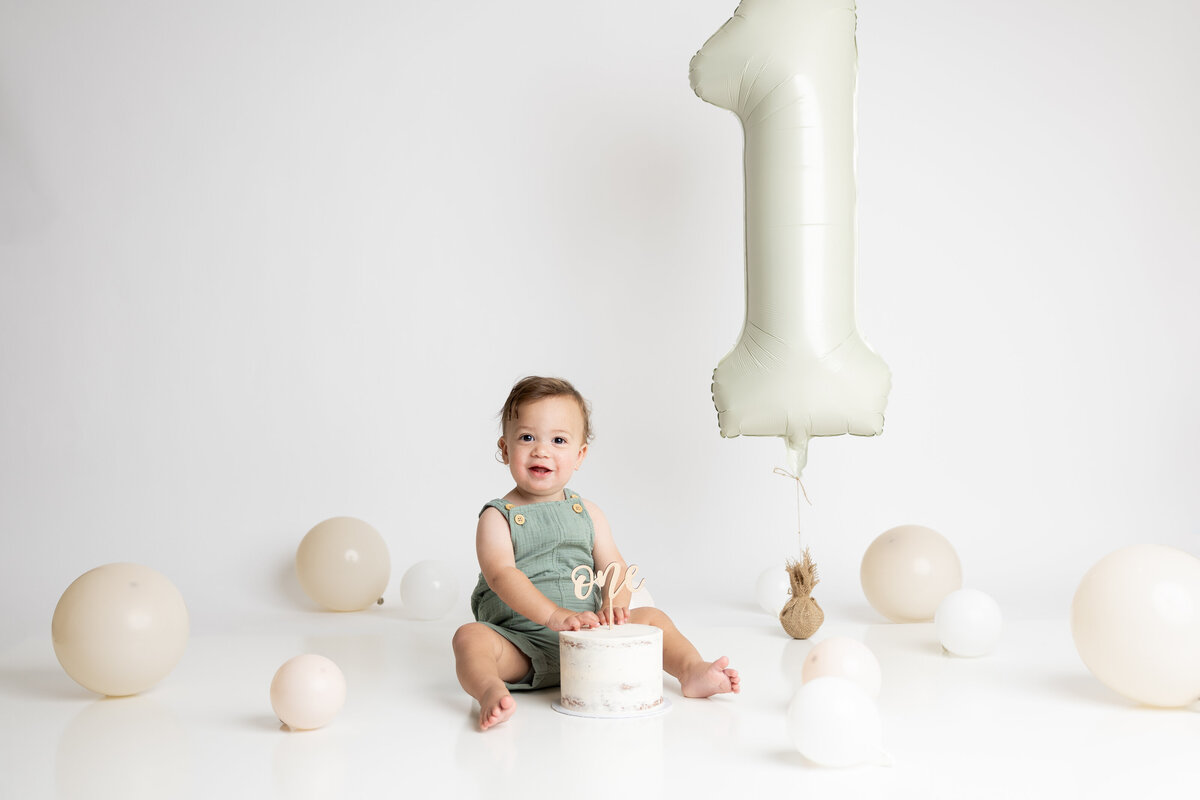 Simple white cake smash with large number one balloon