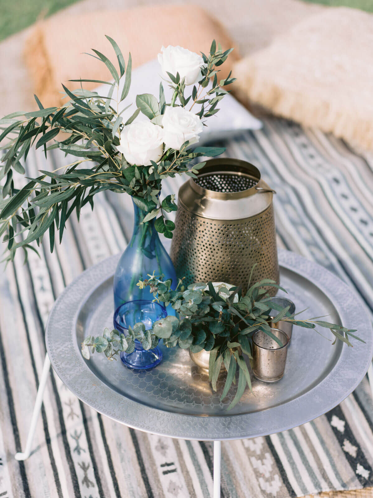 Indonesian bronze pot and cups and blue glass vase with white rose and leaves for a wedding at Bali, Indonesia. Image by Jenny Fu Studio