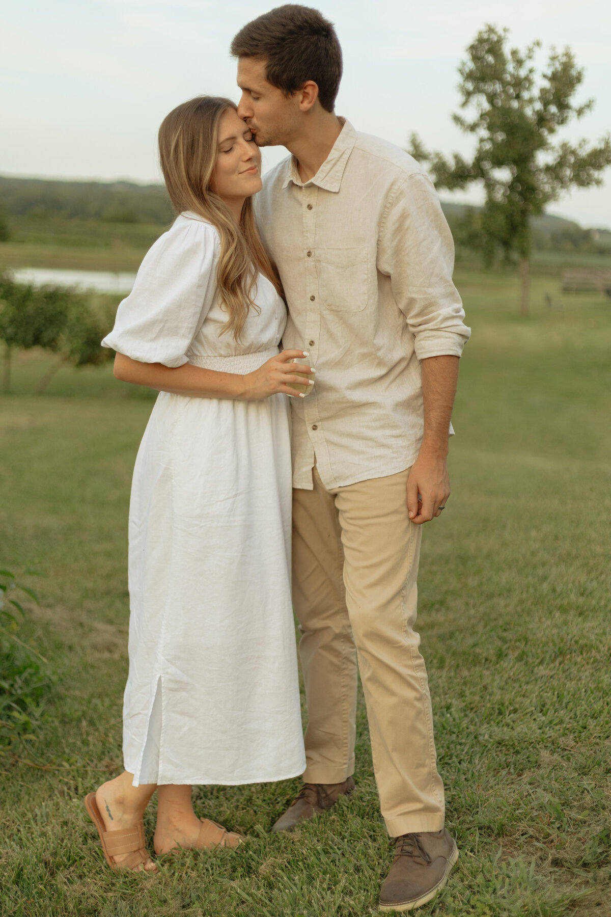 Couple enjoying a cozy picnic with wine and charcuterie at a tropical vineyard

