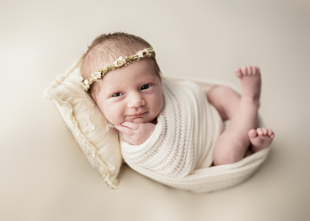 baby on cream backdrop smiling