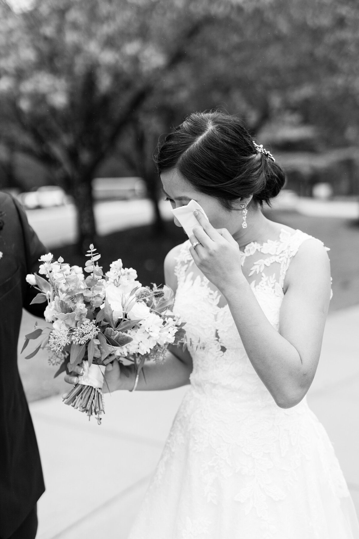 Bride wipes away tear during her first look with her groom on her wedding day in Raleigh, NC.