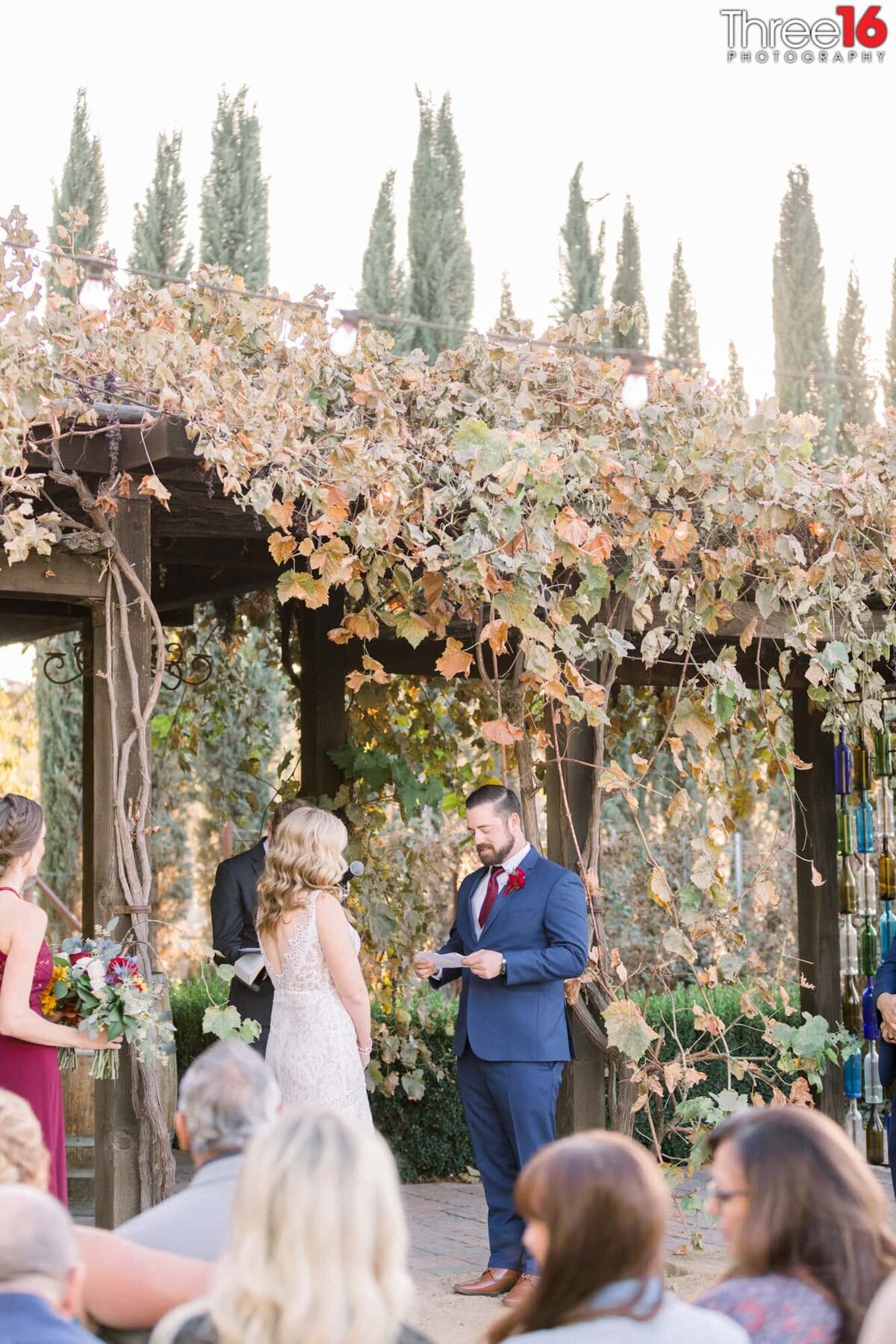 Bride faces her Groom at the altar as he reads his vows to her