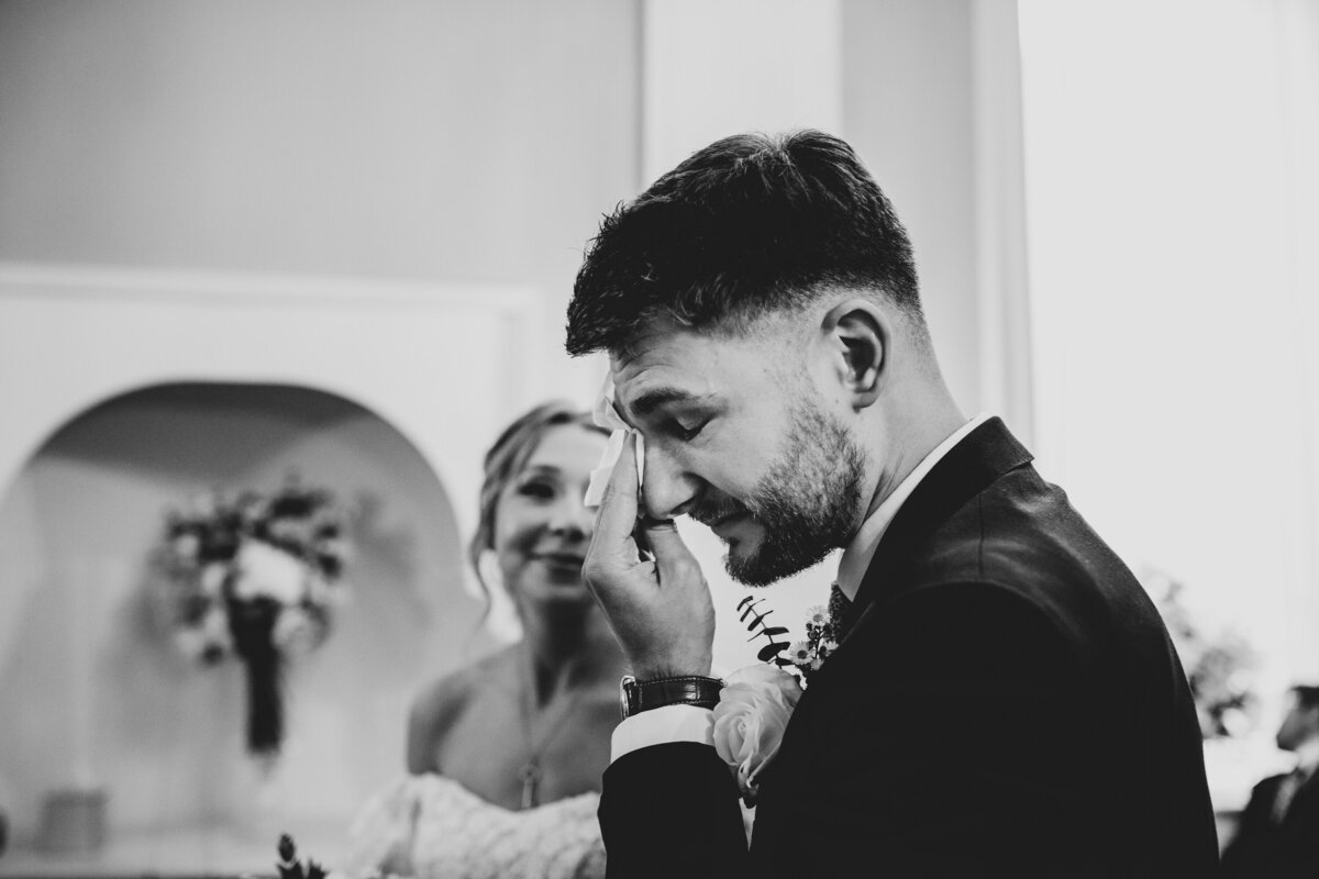 Black and white image of intimate moment during wedding ceremony vows