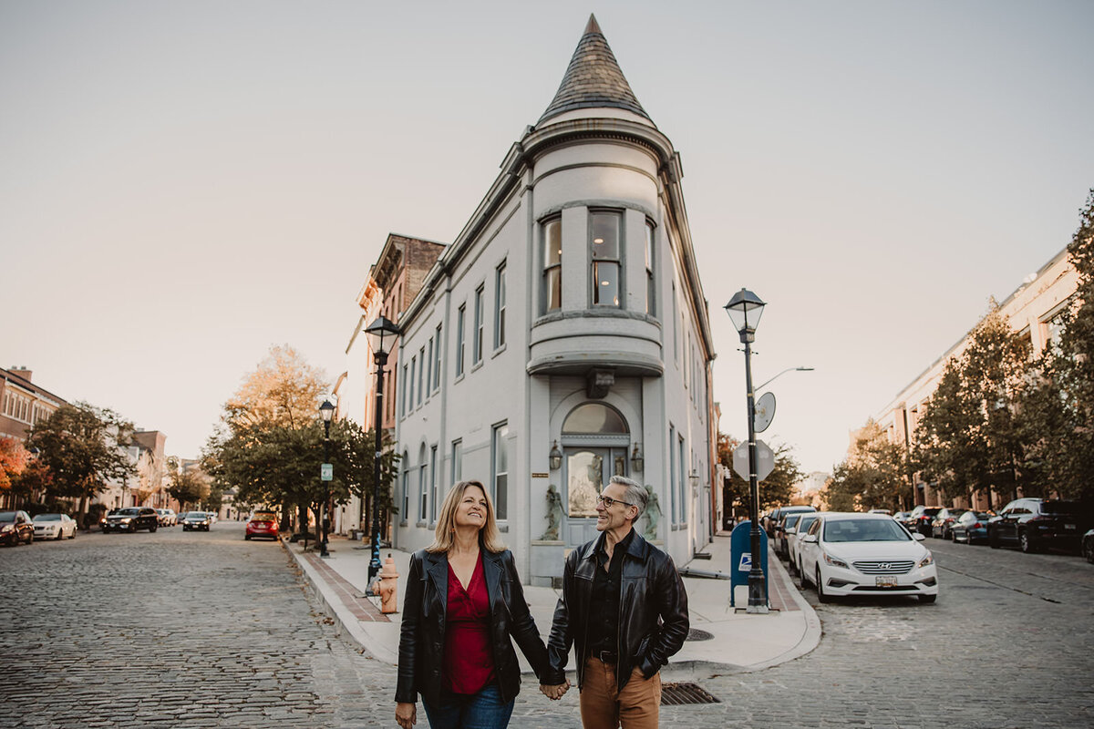 A couple holding hands and walking in a small town 