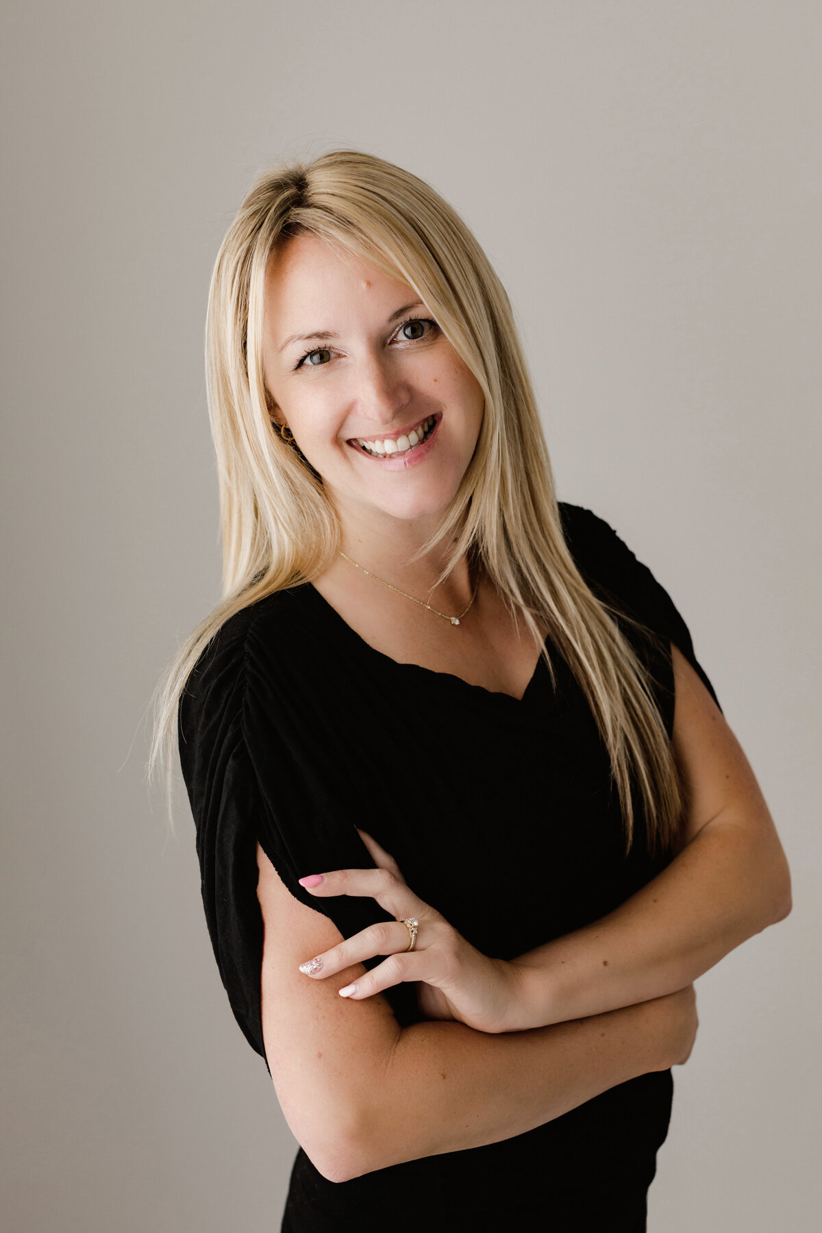 Headshot of a blonde woman smiling in a black top